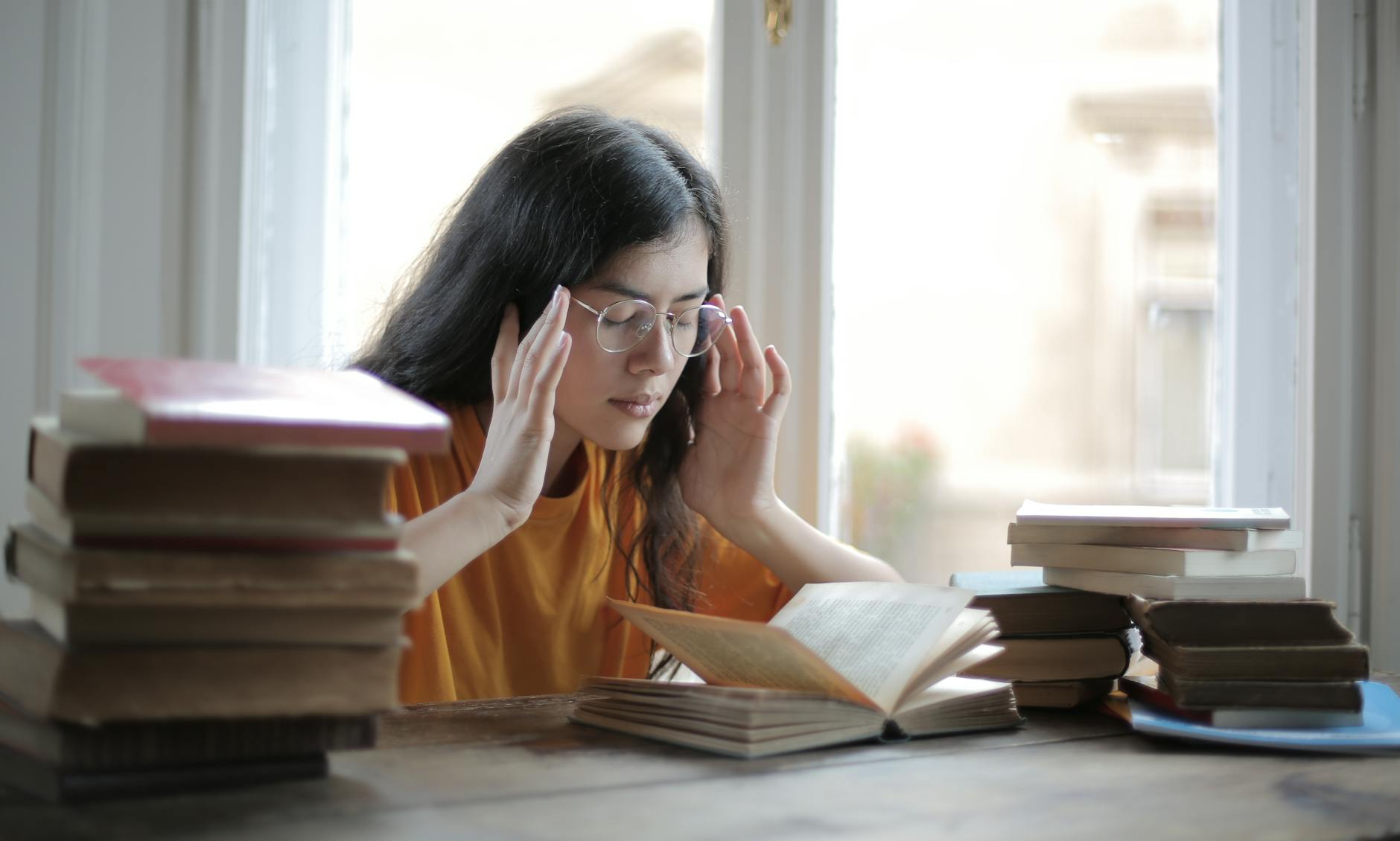 Studentin, Die Unter Kopfschmerzen In Der Bibliothek Leidet